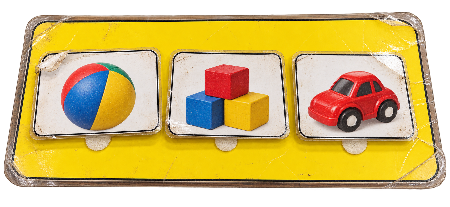 Before: a worn yellow laminated array board with removable picture cards of a ball, blocks and a toy car.